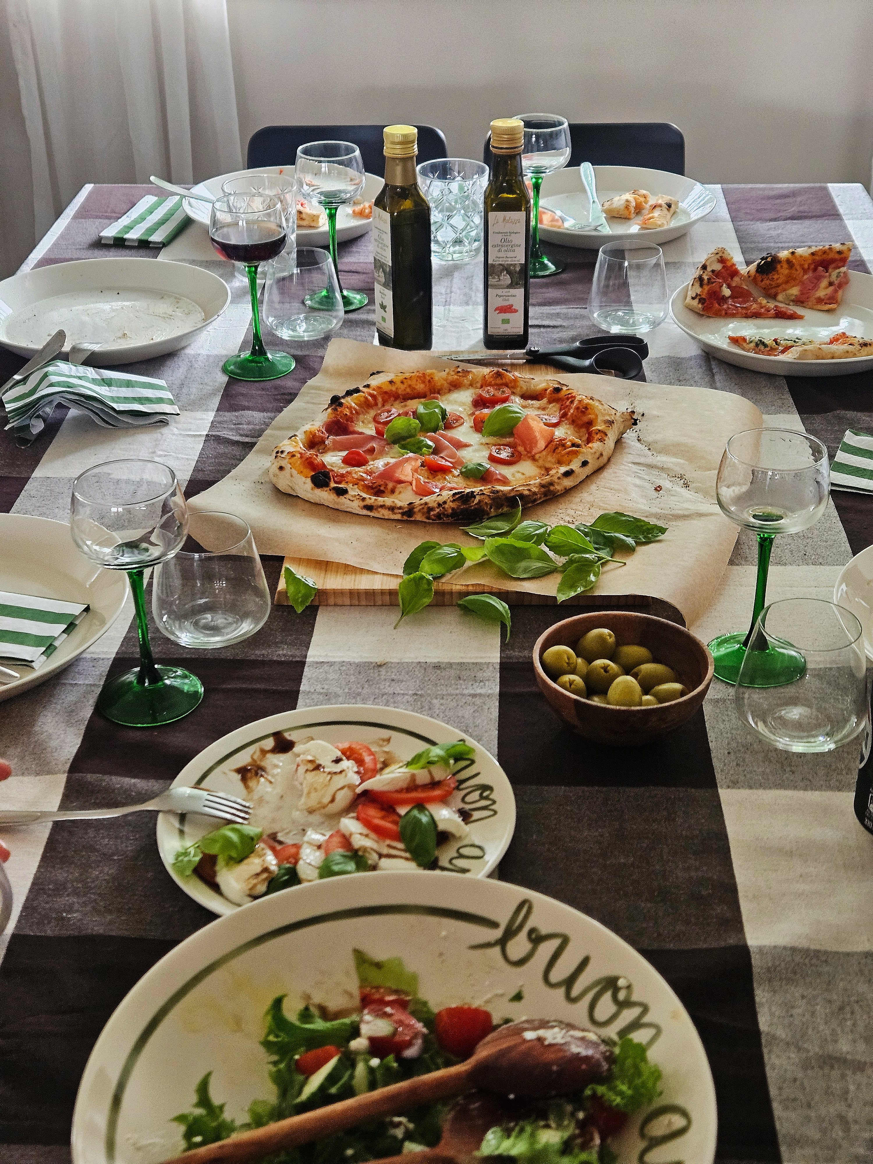 Olive oil drizzled over a finished dish, bottle beside the plate